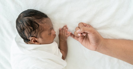 African black parent hands holding newborn baby fingers, Closeup motherâs hand holding their new born baby day. Together love harmony family nursery healthcare and medical fatherâs day concept bannerの写真素材