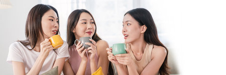 Portrait of young beautiful asian woman group hands holding coffee cup gossip morning time in living room Happy cheerful relax in summer. Korean asian makeup wakeup university asia together lifestyleの写真素材