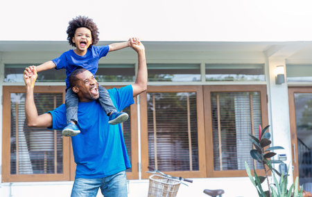Happy black African American father daughter playing home outdoor. Afro man carry piggyback little toddler super hero boy. Cheerful family bonding together fatherâs day concept banner with copy spaceの写真素材