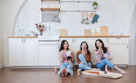 Portrait of  young mixed diverse  friends eating ordered noodles pizza in kitchen home party. Happy asian young girl friends enjoy spending free weekend vacation time together. Fast delivery foodの写真素材