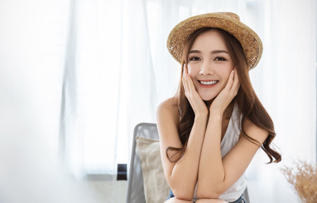 Portrait of young beautiful asian woman hands touch cheek on holiday vacation summer time in white. Happy cheerful relaxing girl in summer. Korean makeup skincare university, woman fashion lifestyleの写真素材