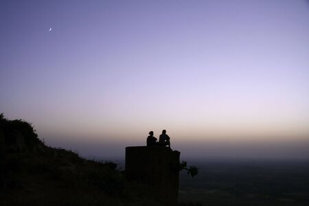 couple chilling out on top of hillの写真素材