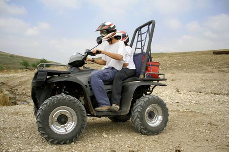 men riding on a quad in desert