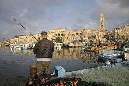 rod fisherman in akko harbour; israelの写真素材