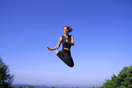 healthy young woman jumping with joyの写真素材