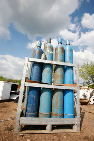 Blue gas bottles stored in junkyard siteの写真素材