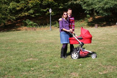 Young couple with pram in park on a sunner autumn dayの写真素材