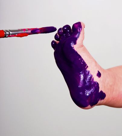 painting a babyfoot purple with a brushの写真素材