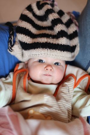young blue eyed baby dressed with woollen capの写真素材