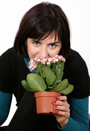 Young woman smelling flowers in a potの写真素材