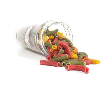 Glass jar of macaroni spilt on isolated white background の写真素材