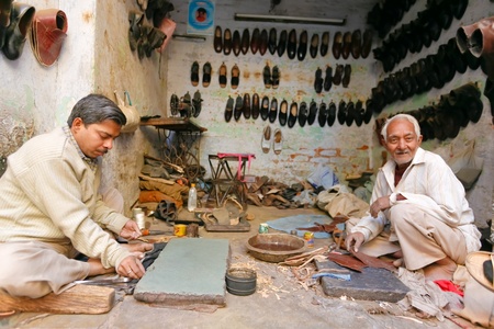 Delhi - January 27: Men in workshop fixing shoes with tools of trade on January 27th, 2008 in Delhi, India.のeditorial素材