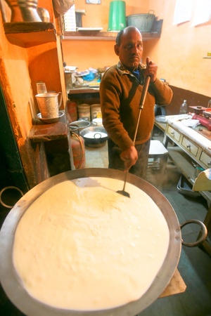 DELHI - JANUARY 14: Man preparing kheer at roadside sweetshop on January 14, 2008 in Delhi, India. A traditional South Asian sweet dish, made by boiling rice or broken wheat with milk and sugar.のeditorial素材