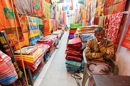 DELHI - FEBRUARY 12: Shopkeeper inside shop selling textile on February 12, 2008 in Delhi, India.  India's Textile Exports have grown exponentially over the last decade.のeditorial素材