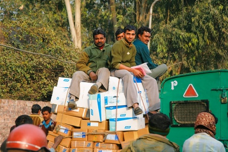 DELHI - JANUARY 19: Men sitting on top of pile of parcels being transported for delivery January 19, 2008 in Delhi, India.のeditorial素材