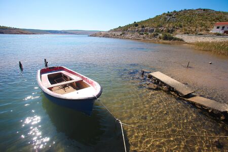 Old moored boat in a lonely bay on the Croatian coastのeditorial素材