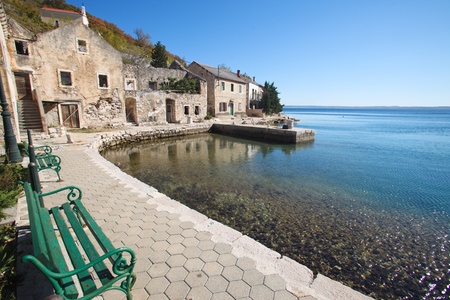Benches on stone walkway in little fishing village along the Croatian coastのeditorial素材