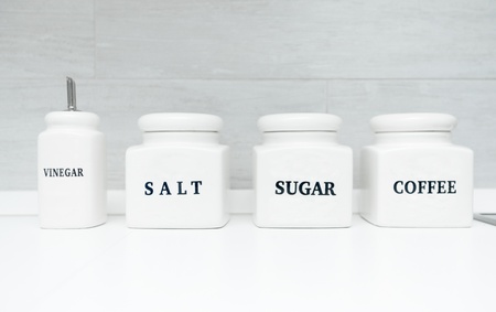 Vinegar, salt, sugar and coffee containers in kitchenの写真素材