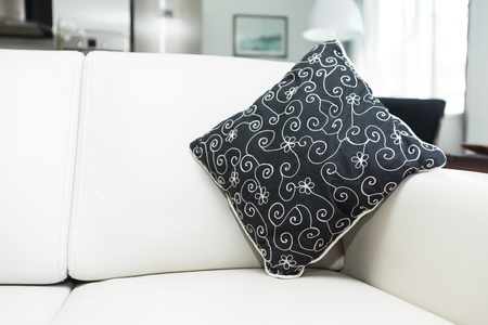 Cushion on modern leather sofa in cozy home