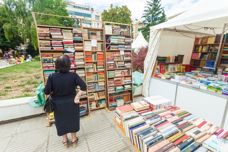 SARAJEVO, BOSNIA - AUGUST 11, 2012  Old lady lookin in bookshelf in street on August 11, 2012 in Sarajevo, Bosnia On the streets of Sarajevo, you can buy almost everything, as well as books のeditorial素材