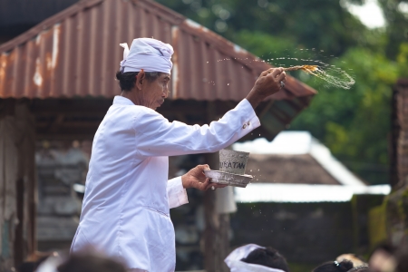 BALI - FEBRUARY 1. Priest blessing worshippers with holy water for Galungan ceremony on February 1, 2012 in Bali, Indonesia. Galungan's a Balinese holiday occuring every 210 days lasting 10 days.のeditorial素材