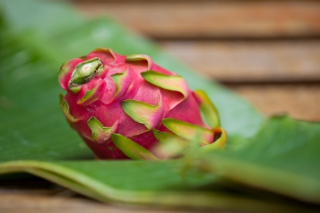 Dragon fruit on banana leaf on wooden tableの写真素材