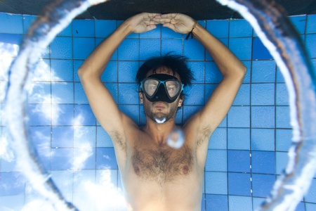Man making bubble rings underwater in poolの写真素材