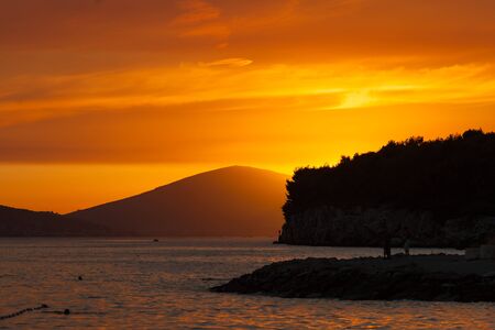 Orange sunset over the sea and coastline in Split, Croatia.の写真素材