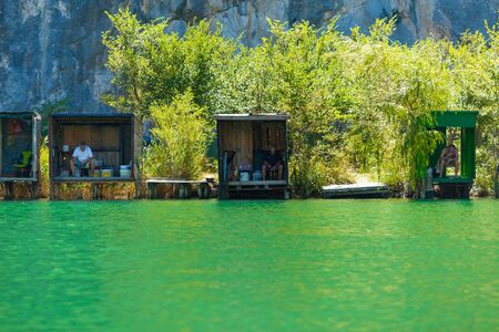 OMIS, CROATIA - AUGUST 28, 2012: People in fishing lodges on the River Cetina on August 28, 2012 in Omis, Croatia. Cetina River empties into the sea in Omis.のeditorial素材