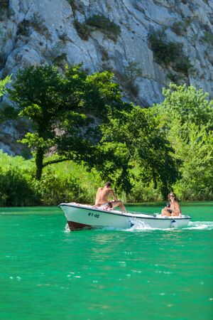 OMIS, CROATIA - AUGUST 28, 2012: Boy and girl in boat  going on the tour on the River Cetina on August 28, 2012 in Omis, Croatia. Cetina River empties into the sea in Omis.のeditorial素材