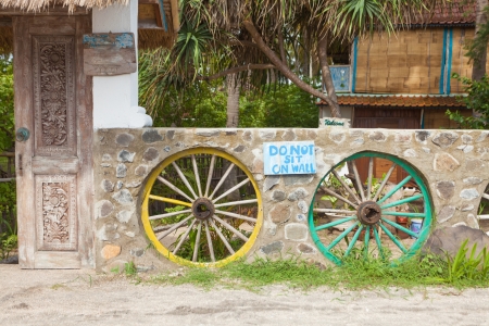 Wall designed with wooden cartwheels painted in yellow and greenのeditorial素材