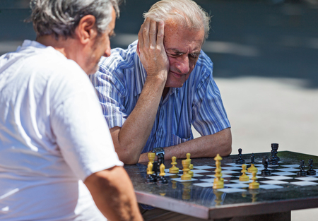 BELGRADE, SERBIA - AUG 15: Old men playing chess on  the street on August 15, 2012 in Belgrade, Serbia. City has plan to put chessboards on public surfaces.のeditorial素材