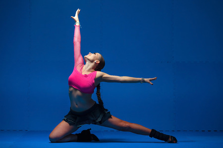 Young dancer in movement on blue backgroundの写真素材