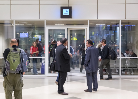 DOHA, QATAR - FEBRUARY 18, 2014: People in and in front of the smoking room at Doha International...