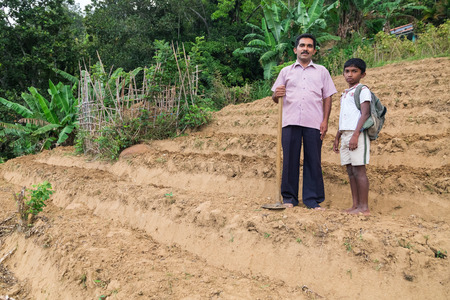 ELLA, SRI LANKA - MARCH 2, 2014: Local farmer and his son stand on tea plantation. Ella is famous for the tea plantations and stunning views across the countryside.のeditorial素材