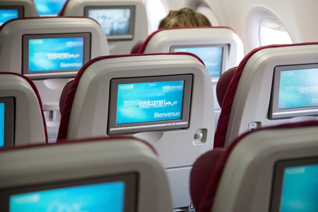 DOHA, QATAR - FEBRUARY 18, 2014: Economy class seats with entertainment system onboard. Qatar Airways Economy Class was named best in the world in the 2009 and 2010 Skytrax Awards.のeditorial素材