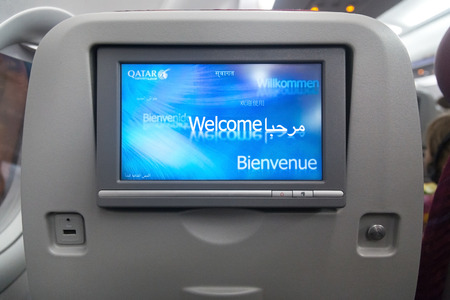 DOHA, QATAR - FEBRUARY 18, 2014: Economy class seat with entertainment system onboard. Qatar Airways Economy Class was named best in the world in the 2009 and 2010 Skytrax Awards.のeditorial素材