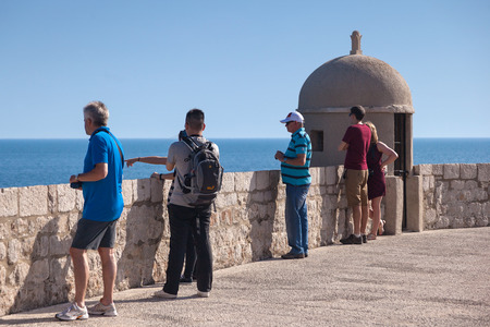 DUBROVNIK, CROATIA - MAY 26, 2014: Tourists on Old city walls with Adriatic sea in background. Old wall is one of Dubrovnik's most famous feature. It is almost 2 km long.のeditorial素材