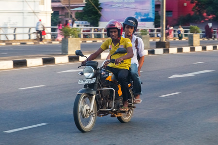 GALLE, SRI LANKA - MARCH 7, 2014: Local men riding motorcycle on street of Galle. Motorcycling is one of main transportation for the local people in the country.のeditorial素材