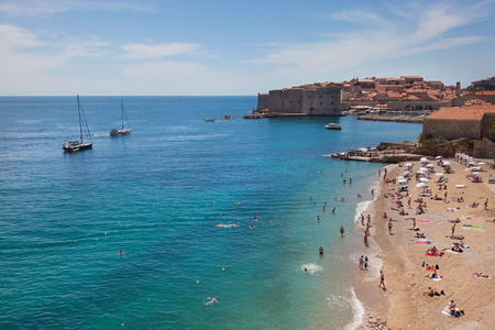 DUBROVNIK, CROATIA - MAY 28, 2014: People on Banje beach with Old town in background. Banje is most popular beach in Dubrovnik very close to town.のeditorial素材