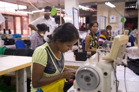 COLOMBO, SRI LANKA - MARCH 12, 2014: Local women working on sewing machine in apparel industry. The manufacture and export of textile products is one of the biggest industries in Sri Lanka.のeditorial素材