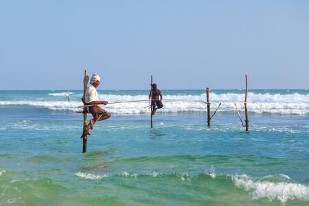 UNAWATUNA, SRI LANKA - MARCH 9, 2014: Stilt Fishermen at Unawatuna. Many of these fishermen earn more money posing for tourists than fishing fish.のeditorial素材