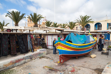MARSAXLOKK, MALTA - JANUARY 11, 2015: Luzzu, traditional eye boat at Marsaxlokk market, one of the city's main features especially on sunday.のeditorial素材