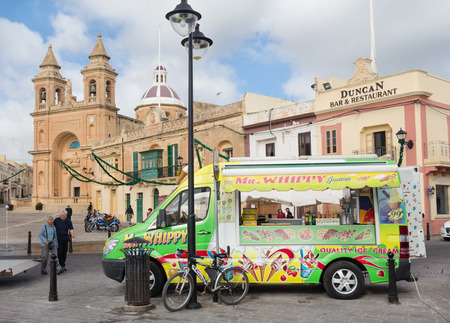 MARSAXLOKK, MALTA - JANUARY 11, 2015: Ice cream truck in front of the Parish Church of Our Lady of Pompei.のeditorial素材
