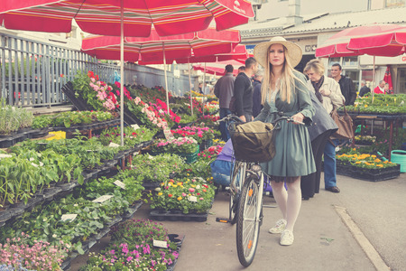 ZAGREB, CROATIA - MARCH 4, 2014: Attractive blonde girl with straw hat and bike on Dolac Market. Dolac has  been the cityのeditorial素材