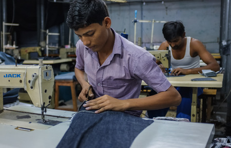 MUMBAI, INDIA - 12 JANUARY 2015: Indian workers sewing in a clothing factory in Dharavi slumのeditorial素材
