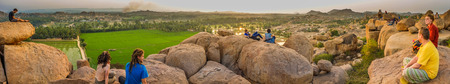 HAMPI, INDIA - 29 JANUARY 2015: Hilltop view of Hampi's boulder strewn landscape and rice paddies with touristsのeditorial素材