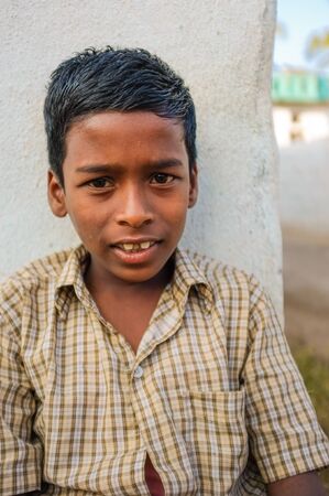 hAMPI, INDIA - 31 JANUARY 2015: Indian boy sitting in street while leaned on wallのeditorial素材
