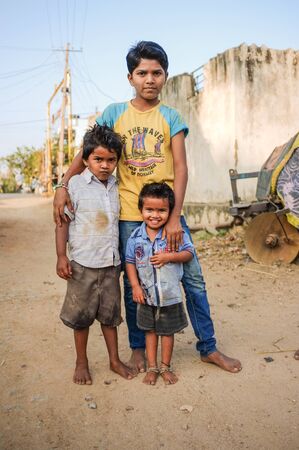 HAMPI, INDIA - 31 JANUARY 2015: Three young Indian boys standing in dusty streetのeditorial素材