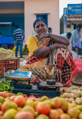KAMALAPURAM, INDIA - 02 FABRUARY 2015: Indian lady selling vegetables on a market close to Hampi